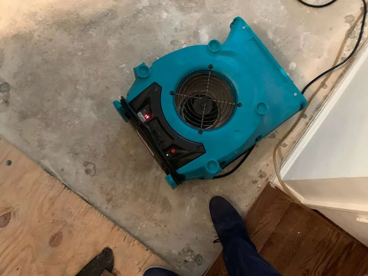 Air mover drying subfloor during Commercial Water Damage Restoration in Mandeville